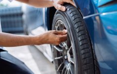pessoa a avaliar sinais de desgaste dos pneus
