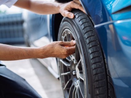 pessoa a avaliar sinais de desgaste dos pneus