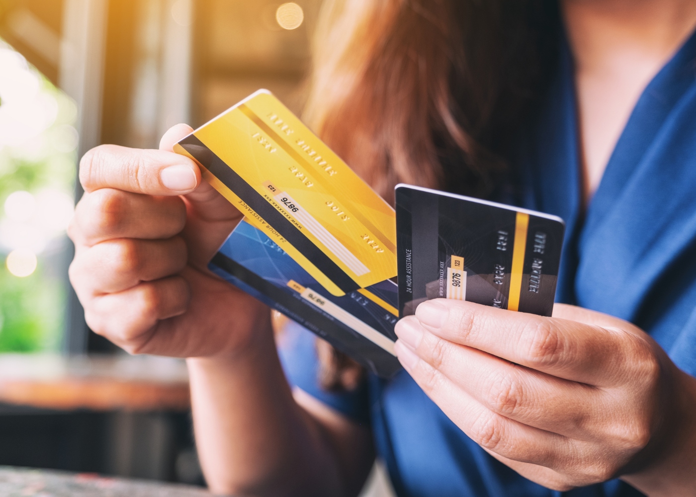 Mulher com vários cartões de crédito na mão