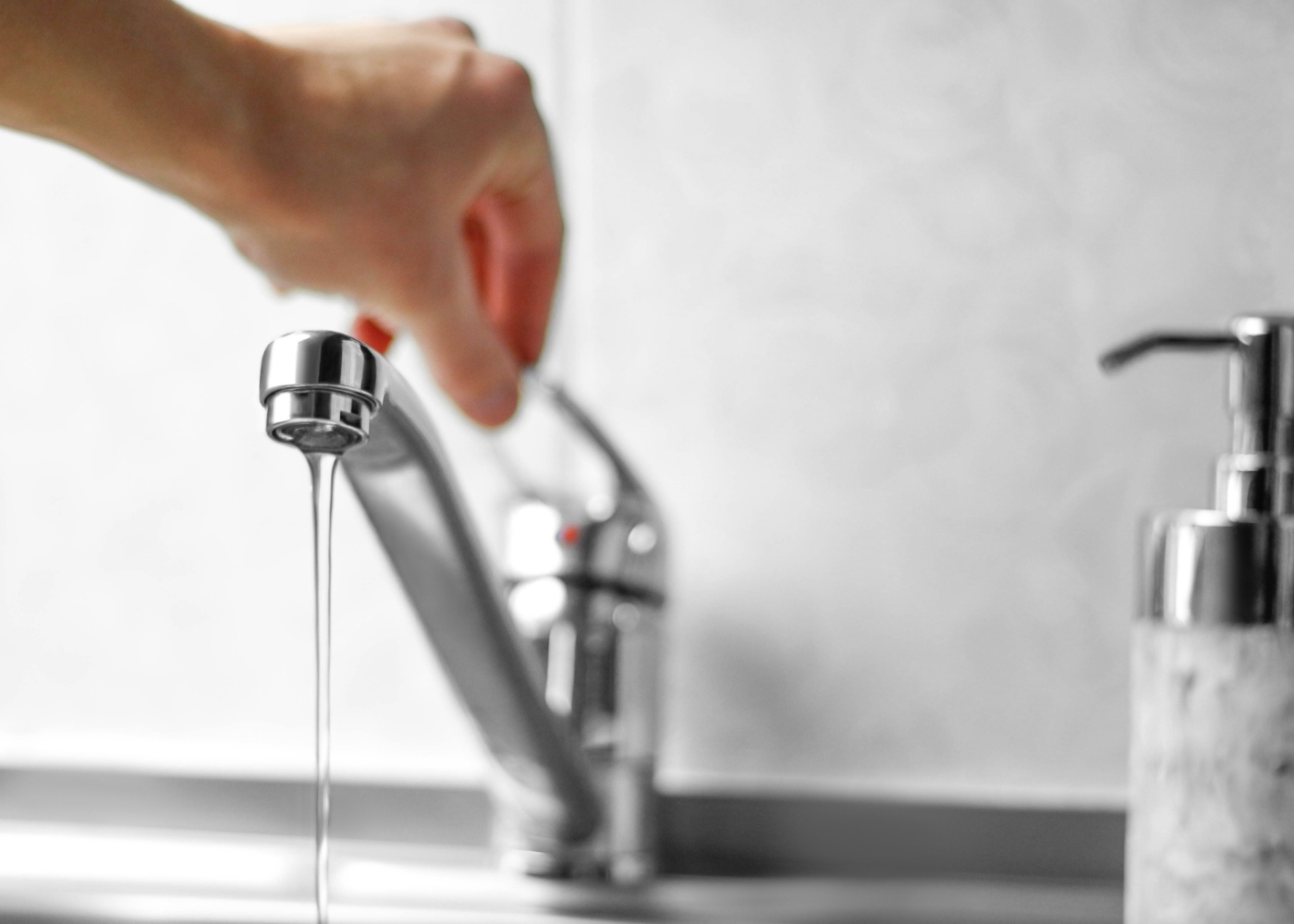 Homem a controlar fluxo de água da torneira para lavar as mãos