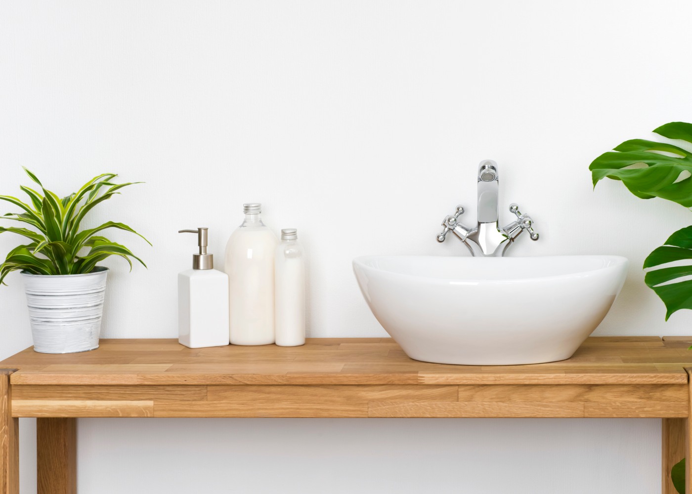 mesa de lavatório com frascos de sabão e plantas