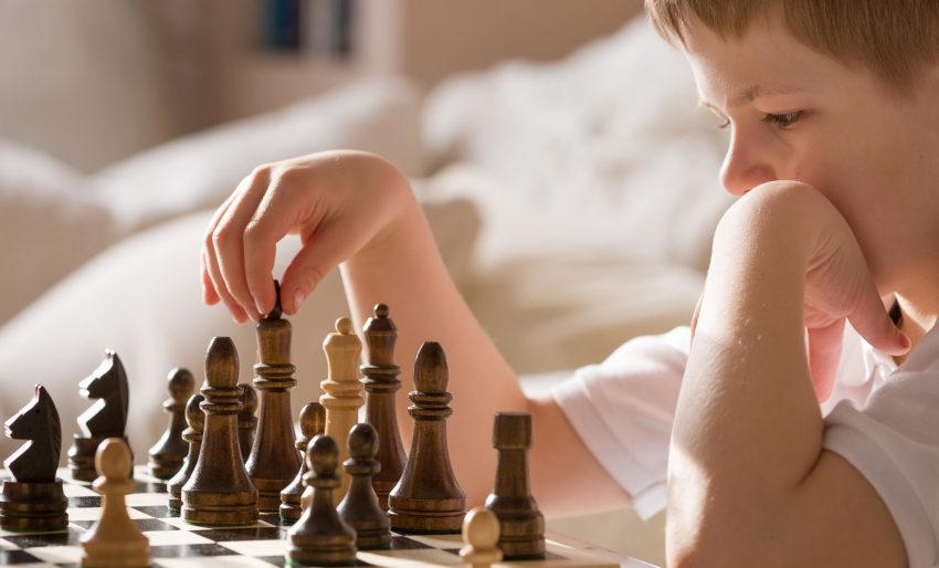 menino sério concentrado desenvolvendo gambito de xadrez, estratégia, jogando  jogo de tabuleiro para vencedor concentração inteligente e criança pensante  enquanto joga xadrez. conceito de aprendizagem, tática e análise. 7292830  Foto de stock