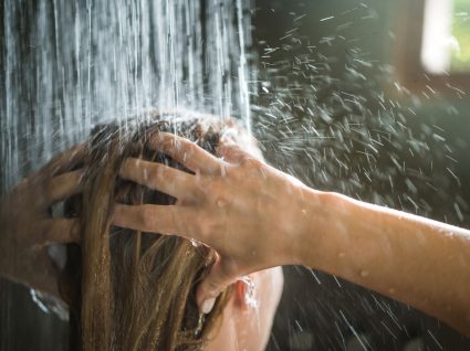 Mulher a lavar o cabelo com esfoliante capilar