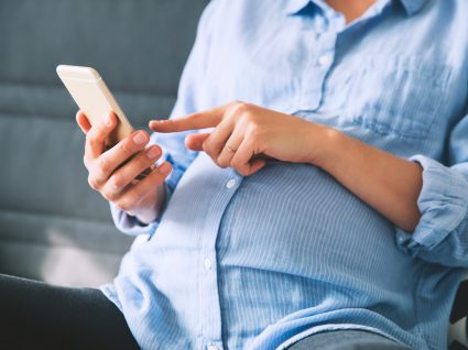 Mulher grávida a usar o telemóvel