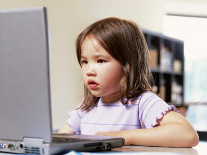 menina da primária a ter aulas em casa via computador