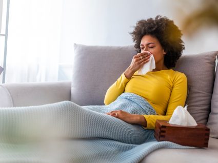 Mulher em casa com sintomas de gripe