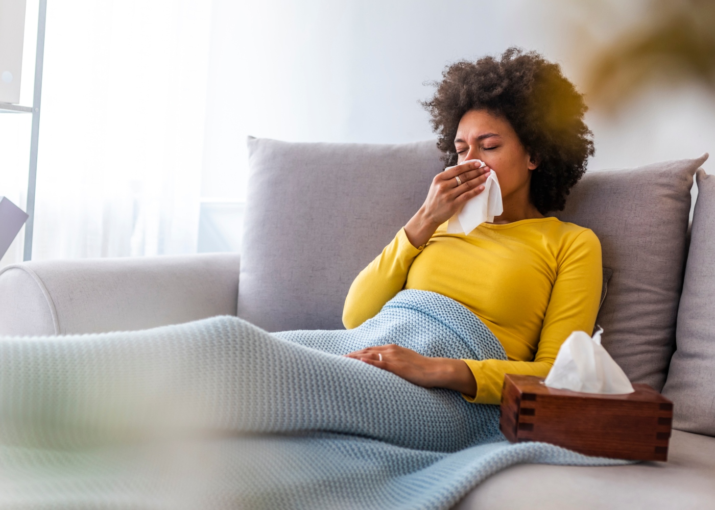 Mulher em casa com sintomas de gripe