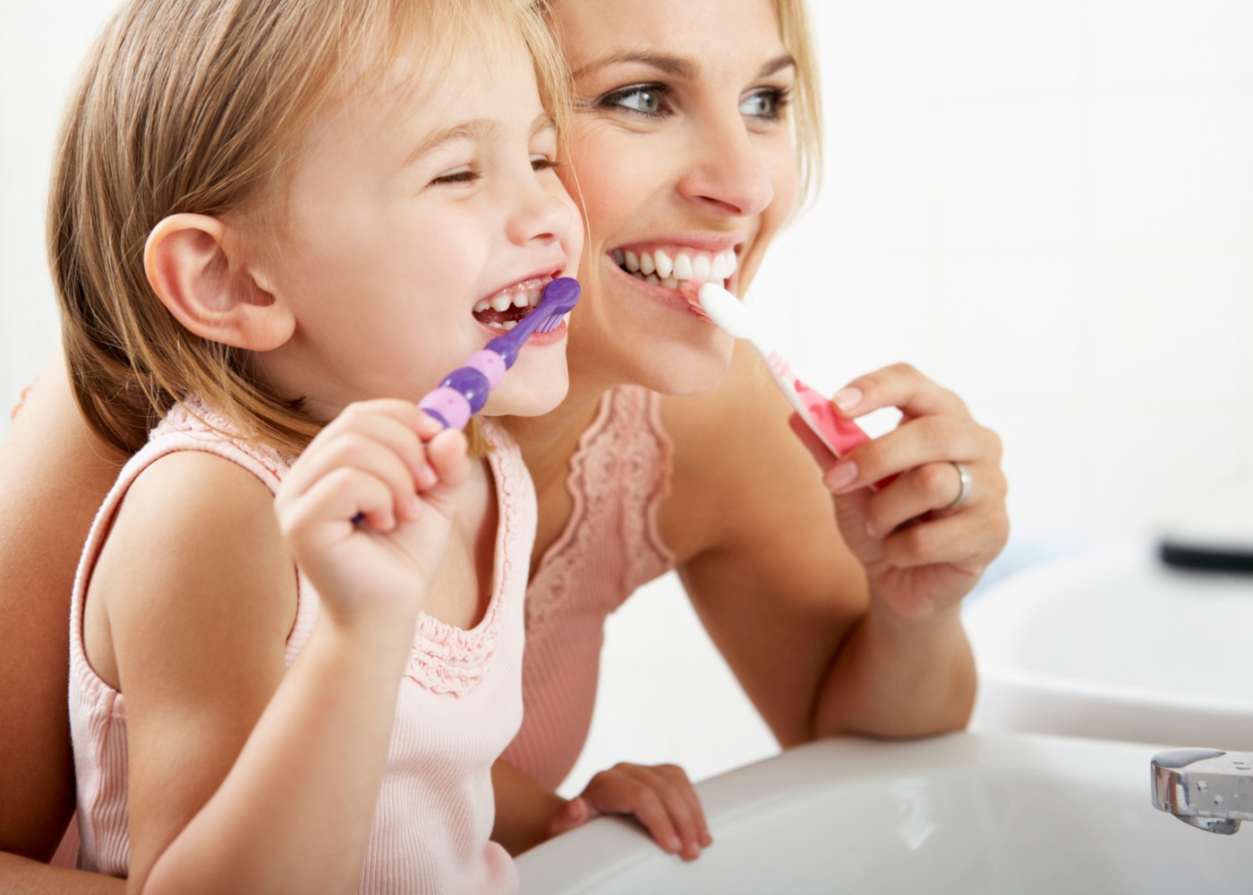 mulher e menina a escovarem os dentes
