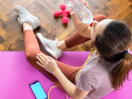 Mulher a treinar em casa com a ajuda de apps de fitness