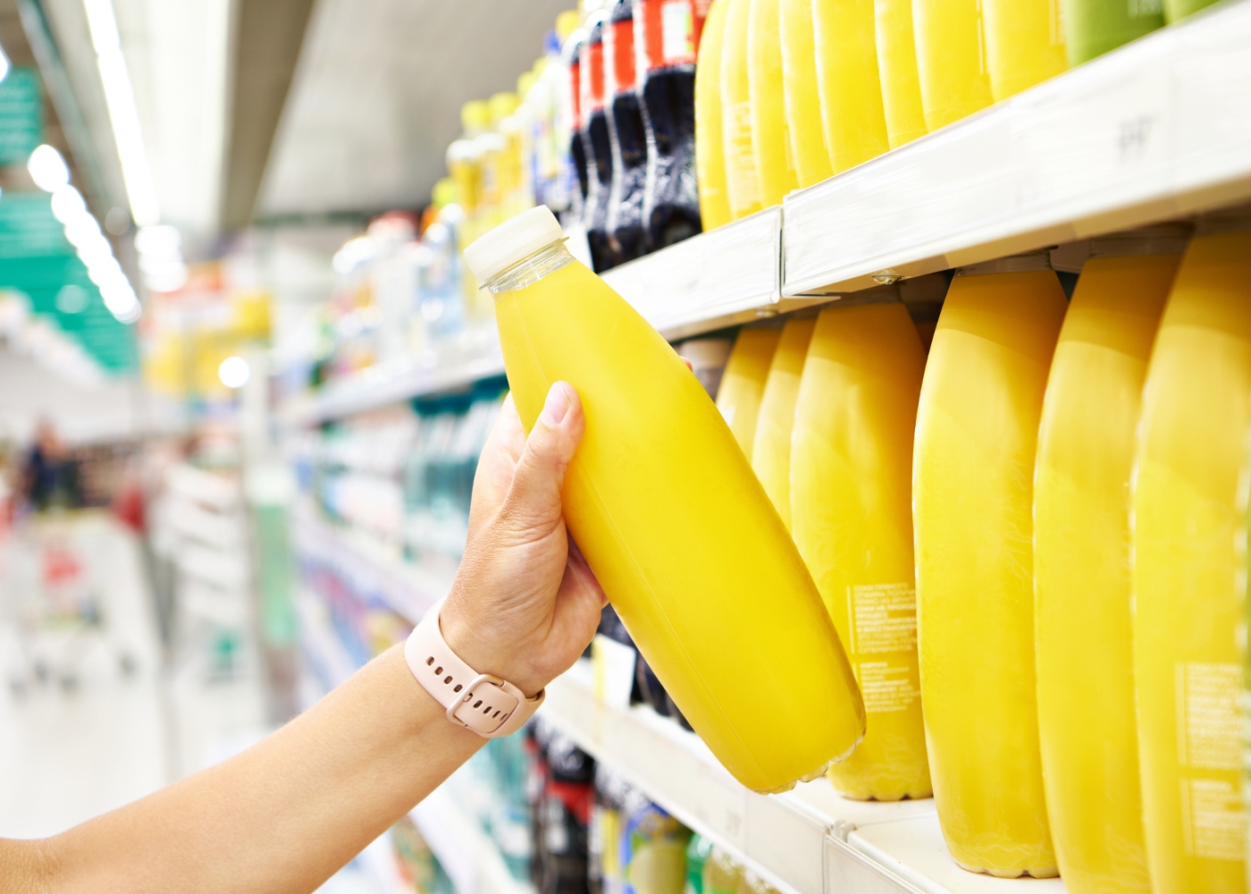 Mulher a comprar refrigerantes no supermercado