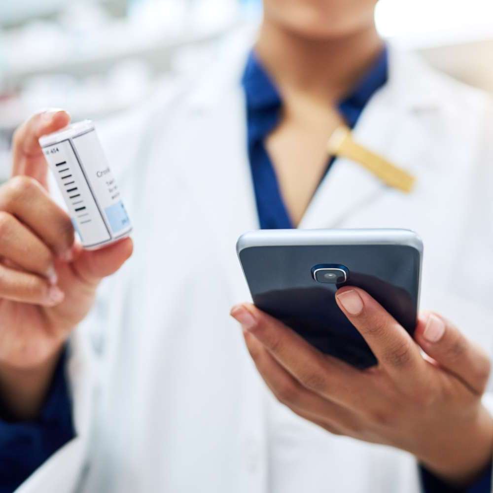 farmacêutica a consultar receita eletrónica no telemóvel do utente