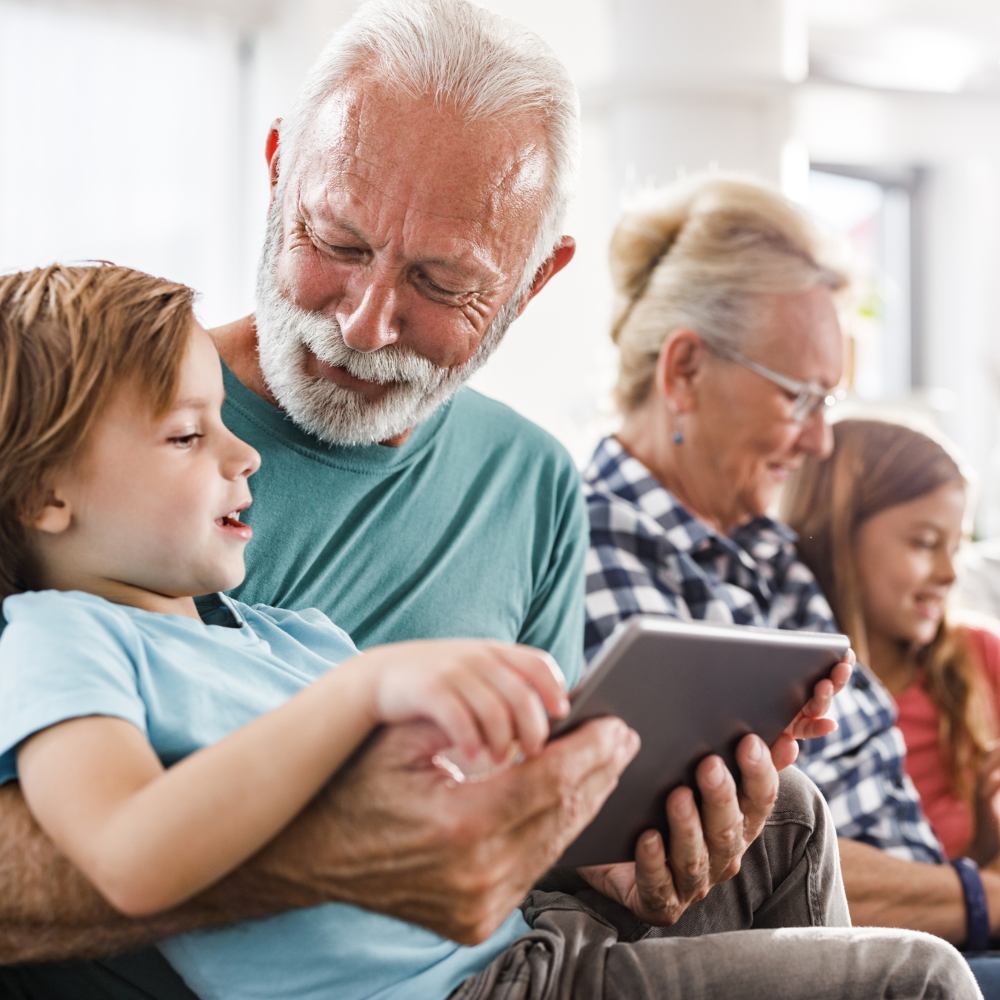 avós e netos a utilizar o tablet e o computador